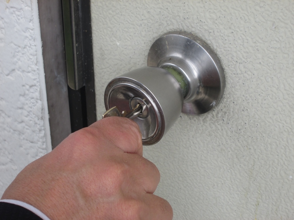 力任せに鍵を開けようとしている男性