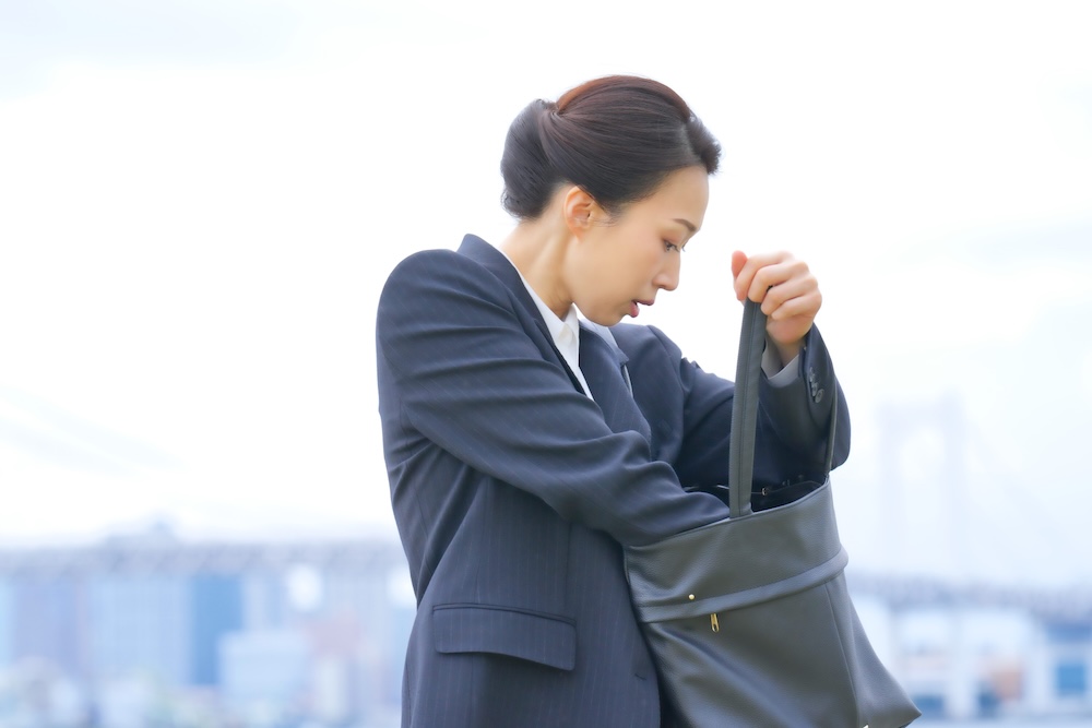 バッグの中を探す女性