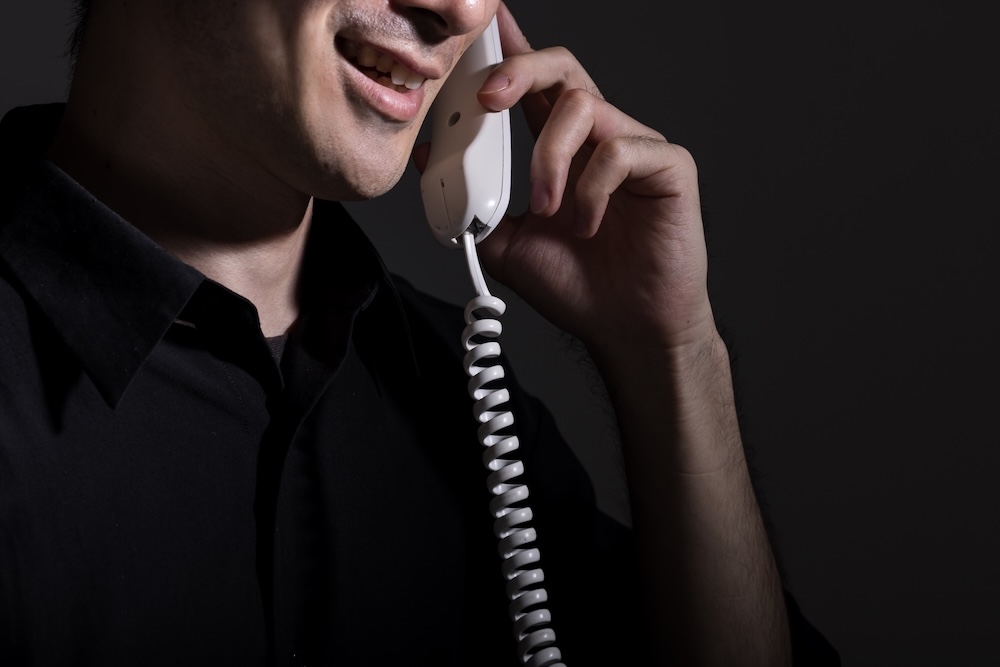 怪しい電話をする男性