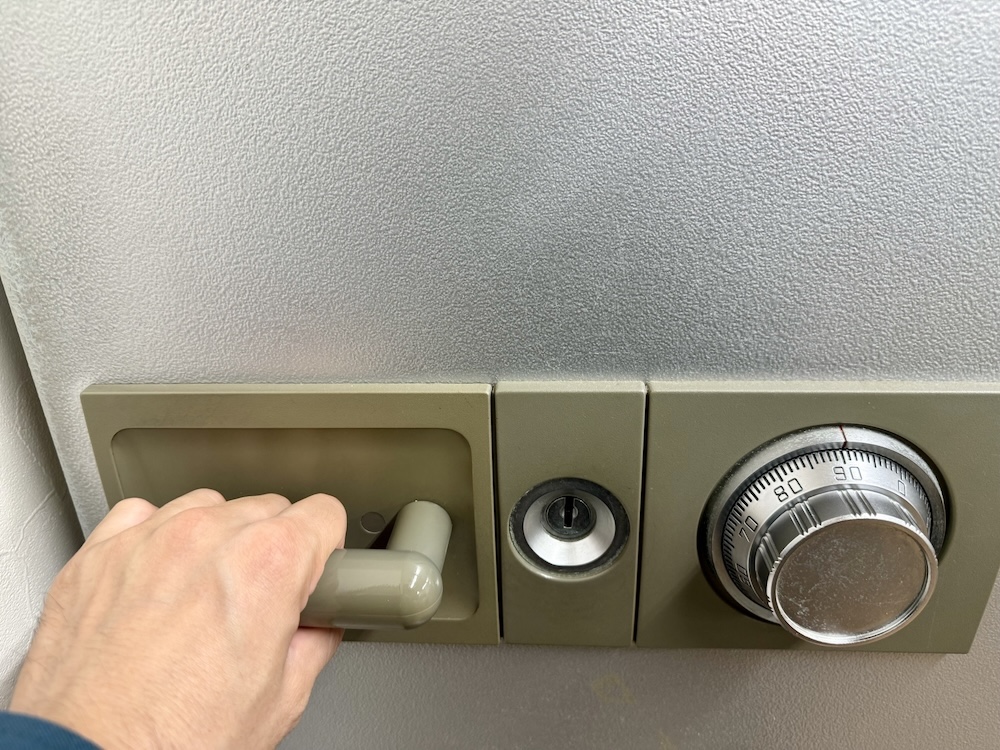 金庫の扉を押しながら開ける様子